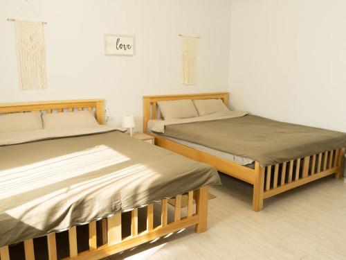 dos camas sentadas una al lado de la otra en una habitación en Newly renovated rental unit with free parking, en Ulán Bator