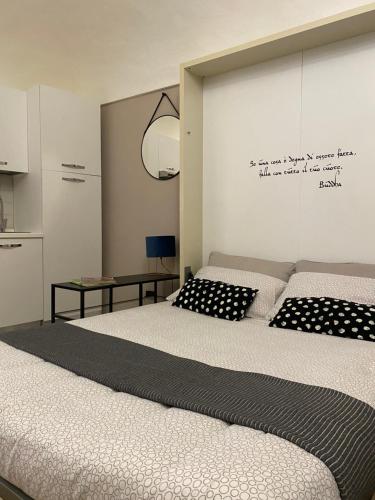 a bedroom with two beds and a sign on the wall at Grigio Perla in Cuneo