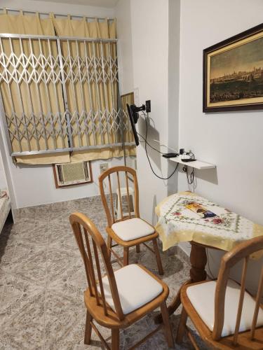 um quarto com 2 cadeiras, uma mesa e uma secretária em Conjugado bem localizado em Copacabana no Rio de Janeiro