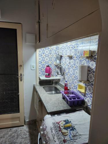 uma pequena cozinha com um lavatório e uma bancada em Conjugado bem localizado em Copacabana no Rio de Janeiro