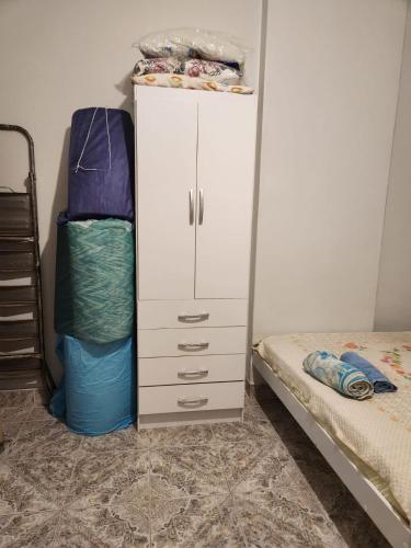 um quarto com um armário branco ao lado de uma cama em Conjugado bem localizado em Copacabana no Rio de Janeiro