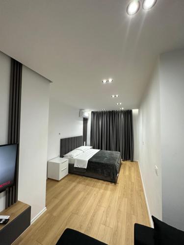 a bedroom with a bed and a flat screen tv at CozyStayApartments in Tirana