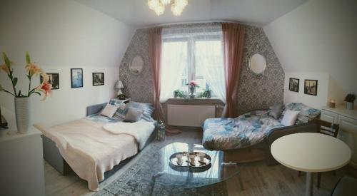 uma sala de estar com uma cama e uma mesa de centro em St Nicolas Attic em Gdansk