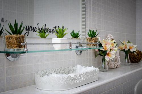 a bathroom counter with potted plants and a mirror at Gyógyvölgy apartman in Egerszalók