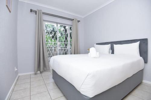 プレトリアにあるComfy Hatfield Appartmentの窓のある部屋にある白いベッド