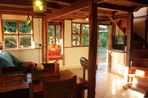 a living room with a couch and a tv and windows at ChacraKremen in El Bolsón