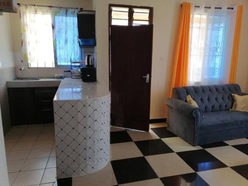 cocina y sala de estar con sofá y barra. en La Grande 1bedroom Apartment Mtwapa, en Mtwapa