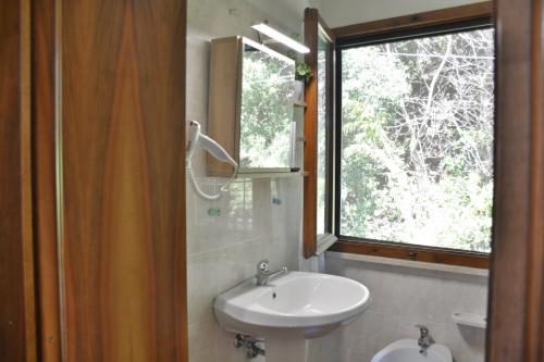 a bathroom with a sink and a window at Hotel Villa Paradiso in Riparbella