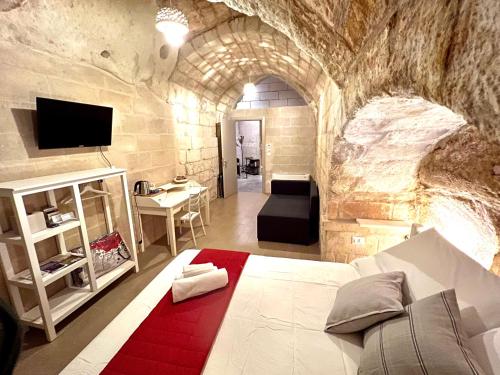 una camera da letto con un letto in un muro di pietra di Alle Grotte a Matera