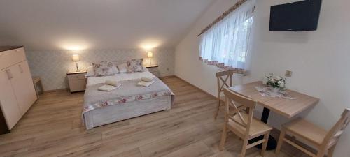 a bedroom with a bed and a table and a desk at Gospodarstwo agroturystyczne U Gazdy in Wisła