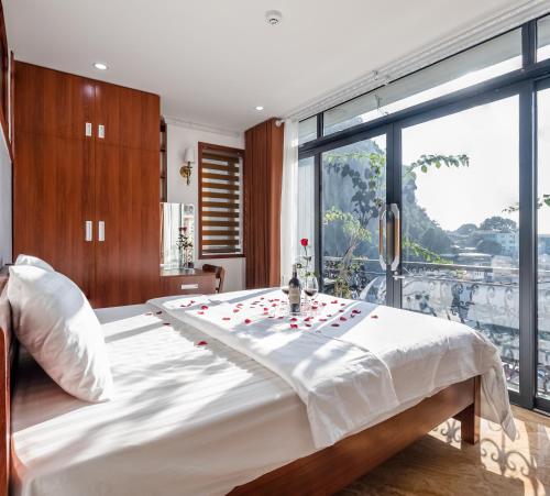 a bedroom with a large bed and a large window at CHÉRIE HOMEHOTEL in Ha Long