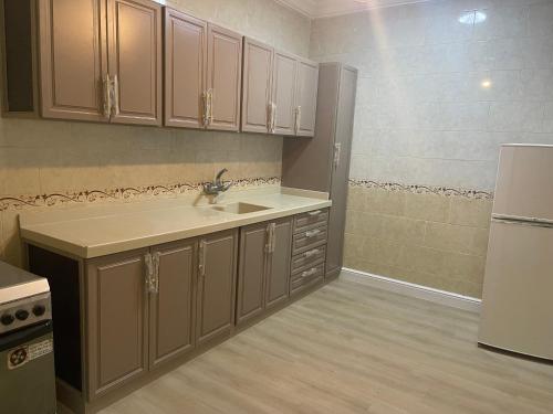 a kitchen with a sink and a refrigerator at فندق نزهة النسيم in Ash Shishah