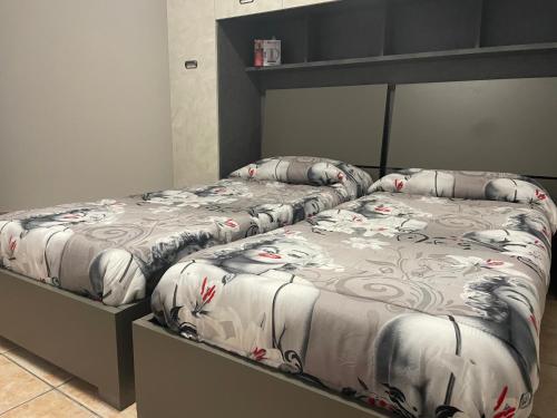 dwa łóżka siedzące obok siebie w sypialni w obiekcie Homesweethome w mieście Porto Torres