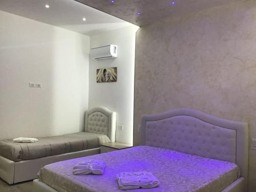 1 dormitorio con cama morada y sofá en Glem beauty, en Copertino