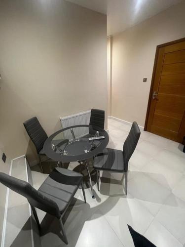 2 Bedroom Apartment,Chester Road N17 في لندن: غرفة طعام مع طاولة وكراسي زجاجية