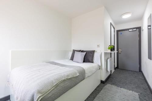 a white bedroom with a white bed and a door at For Students Only Glassworks in Liverpool in Liverpool