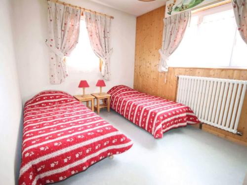 2 camas en un dormitorio con mantas rojas y blancas en Comfortable Holiday Home in Chatel with Roof Terrace, en Châtel