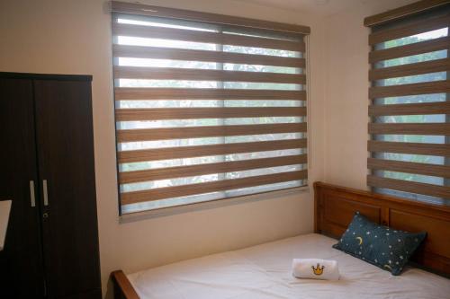 a bedroom with a bed and a window with blinds at Casa Amanda bungalow with hi-speed internet in Coron