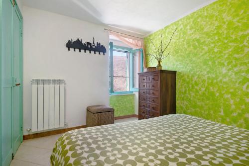 a bedroom with a bed and a green wall at La Fermenteria in San Colombano Certenoli