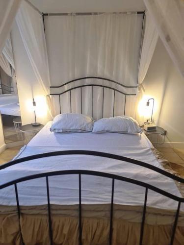 a large white bed with two pillows and two lamps at La parenthèse in Marche-en-Famenne