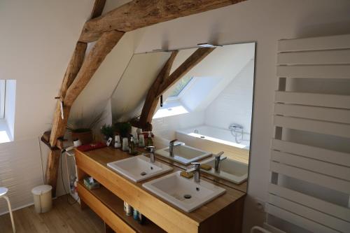 een badkamer met 2 wastafels en een spiegel bij Ferme des Trois Poiriers, Teloché in Teloché