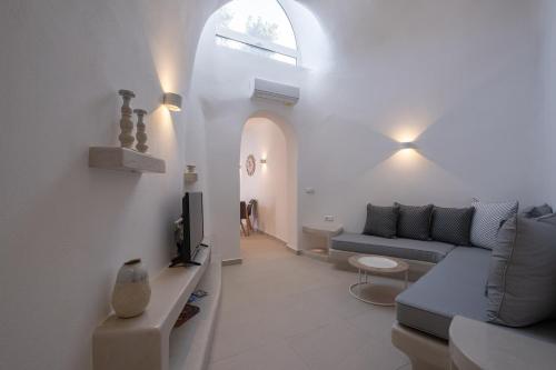 a living room with a couch and a tv at Santoterra Antigua Suites in Karterados