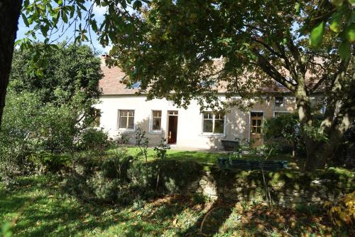 a white house with a tree in front of it at Ferme des Trois Poiriers, Teloché in Teloché