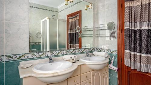 a bathroom with two sinks and a mirror at Villa Caleta Ref 196 in Fuengirola