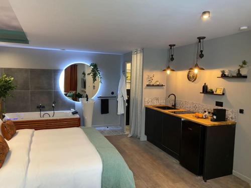 - une chambre avec un grand lit, une baignoire et un lavabo dans l'établissement Suite Garonne - baignoire balnéo duo à bulles - Luxe et charme - climatisation, à Eyrans-de Soudiac