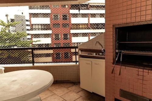 eine Küche mit einem WC, einem Waschbecken und einem Fenster in der Unterkunft Condomínio Edifício Allamanda - Módulo 6 in Bertioga