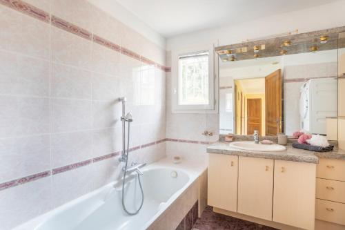La salle de bains est pourvue d'une baignoire et d'un lavabo. dans l'établissement Le Puy du Roy - Climatisé et piscine privée, à Aix-en-Provence