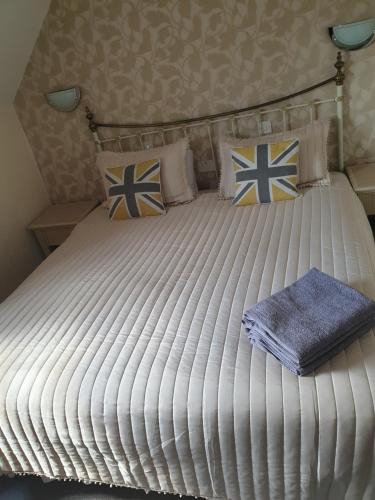 a large white bed with blue and white pillows at The Barley Mow 