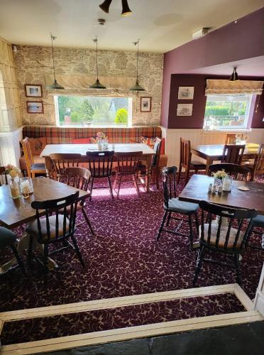 a restaurant with tables and chairs in a room at The Barley Mow in Newbold on Avon