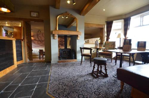 a living room with a fireplace and a table and chairs at The Barley Mow 