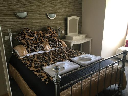 a bedroom with a bed with a black and brown comforter at The Barley Mow 