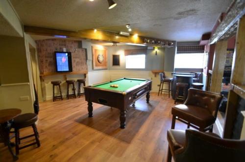 a billiard room with a pool table and a bar at The Barley Mow 