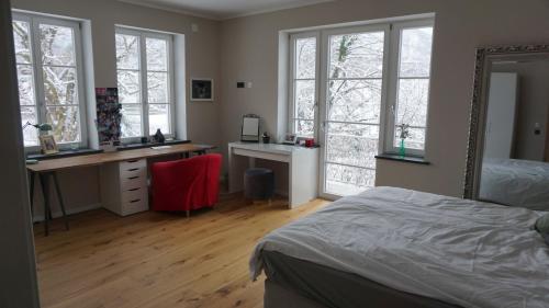 una camera da letto con un letto, una scrivania e finestre di Villa am Wappach a Bayerisch Gmain
