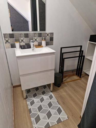 a bathroom with a white sink and a mirror at Gîte la crinière au vent in Étréaupont