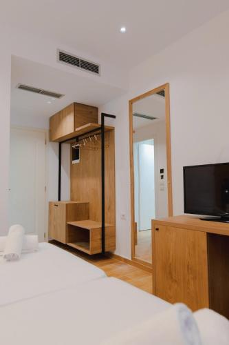 a bedroom with a bed and a flat screen tv at Hotel ABA in Ksamil