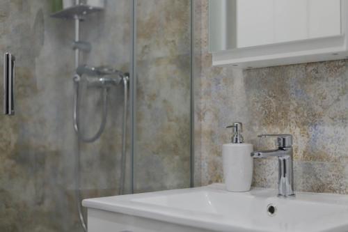 W łazience znajduje się umywalka i prysznic. w obiekcie Apartament z Balkonem w Jastrzębiu Zdroju