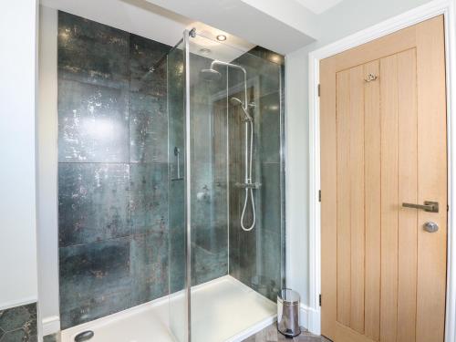 a shower with a glass door in a bathroom at The Eastgate Apartment in Louth