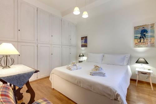 ein Schlafzimmer mit einem großen weißen Bett mit Handtüchern darauf in der Unterkunft Casa Campuccio -Appartamento Campuccio1 e Appartamento Campuccio 2 in Florenz