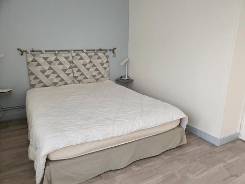 - une chambre avec un lit doté d'un couvre-lit blanc dans l'établissement Horizon, à Saint-Valery-en-Caux