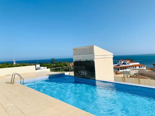 a swimming pool with a view of the ocean at Lux Suites Palm Terraces Apartments Nyali in Nyali