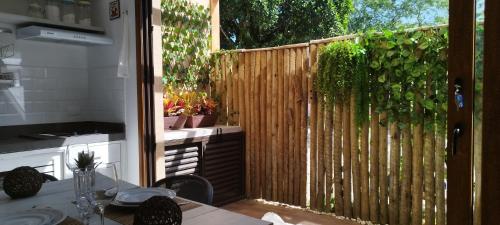 a kitchen with a wooden privacy fence with potted plants at Studio e Suite no Centro de Juquehy a 150mts da praia - Varanda e Serviço de Praia --- E MAIS Ofurô - Cozinha e Estacionamento nas unidades "STUDIO" -- TUDO NOVO in Juquei