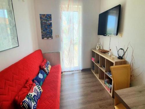 uma sala de estar com um sofá vermelho e uma televisão em Apartment Lucia em Omišalj