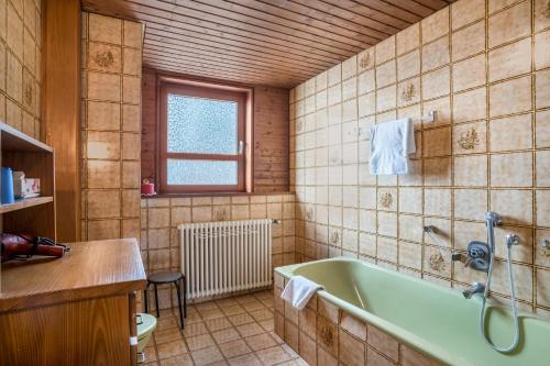 ein Badezimmer mit einer grünen Badewanne und einem Waschbecken in der Unterkunft Adlerhorst in Sasbachwalden