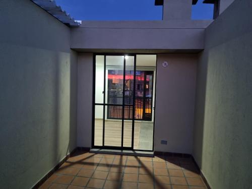 un couloir vide avec une porte menant à une fenêtre dans l'établissement New Comfortable Apartments in La Candelaria, Bogotá, à Bogotá