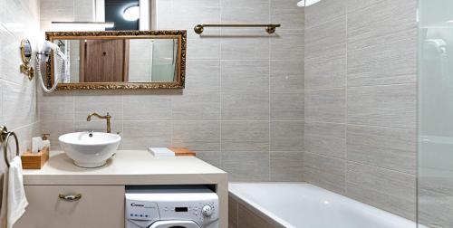 a bathroom with a sink and a mirror and a tub at Sunset Resort 311 in Fonyód
