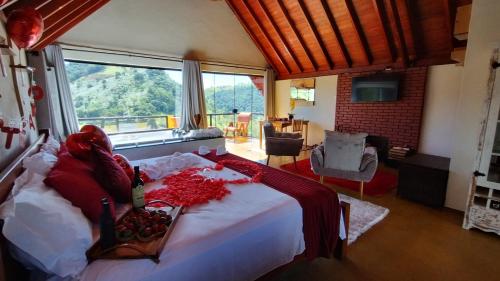 Un dormitorio con una cama con flores rojas. en Chales Sabor Dos Ventos, en Gonçalves